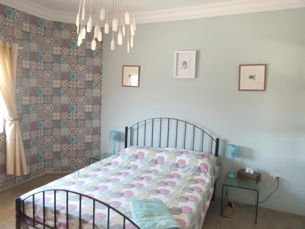 a bedroom with a bed and a chandelier at The Little B&B on the Hill in Wadi Musa