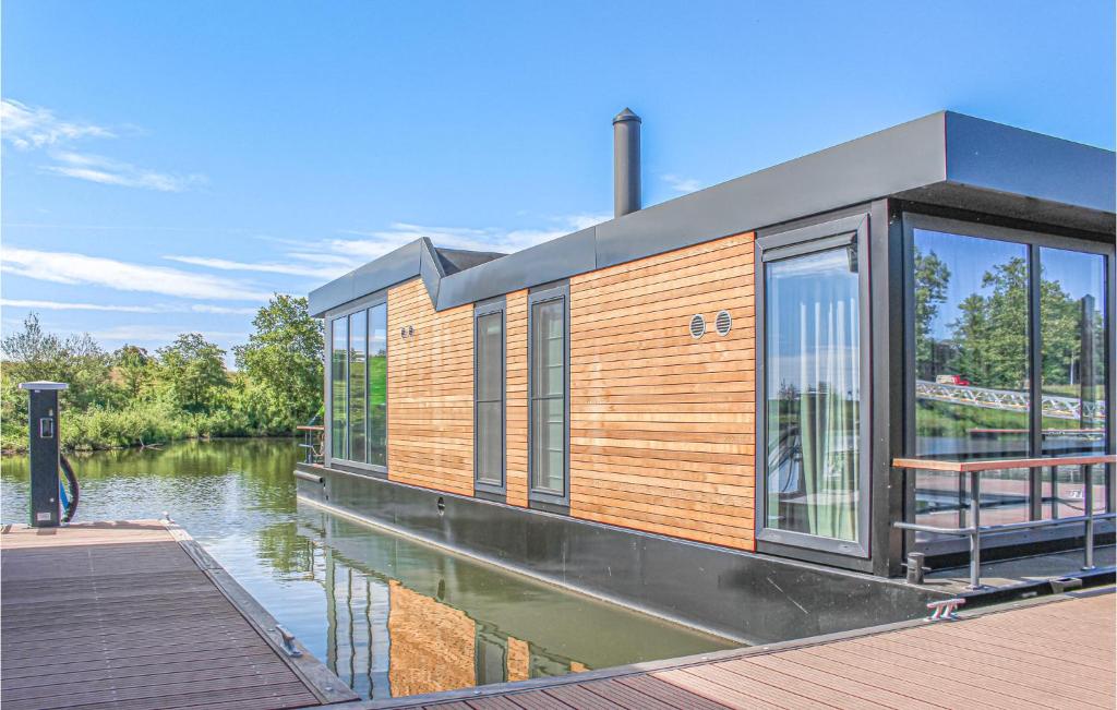 a house on the water next to a river at Stunning Ship In Oh Laak With Kitchen in Ohé en Laak