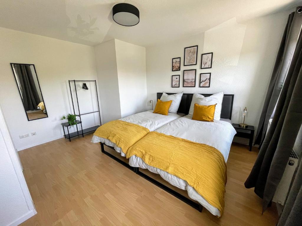 ein Schlafzimmer mit einem Bett mit einer gelben Decke darauf in der Unterkunft Modern 4 Zi Rooms Netflix, Wifi, Parken CasaLuna85 in Flöha