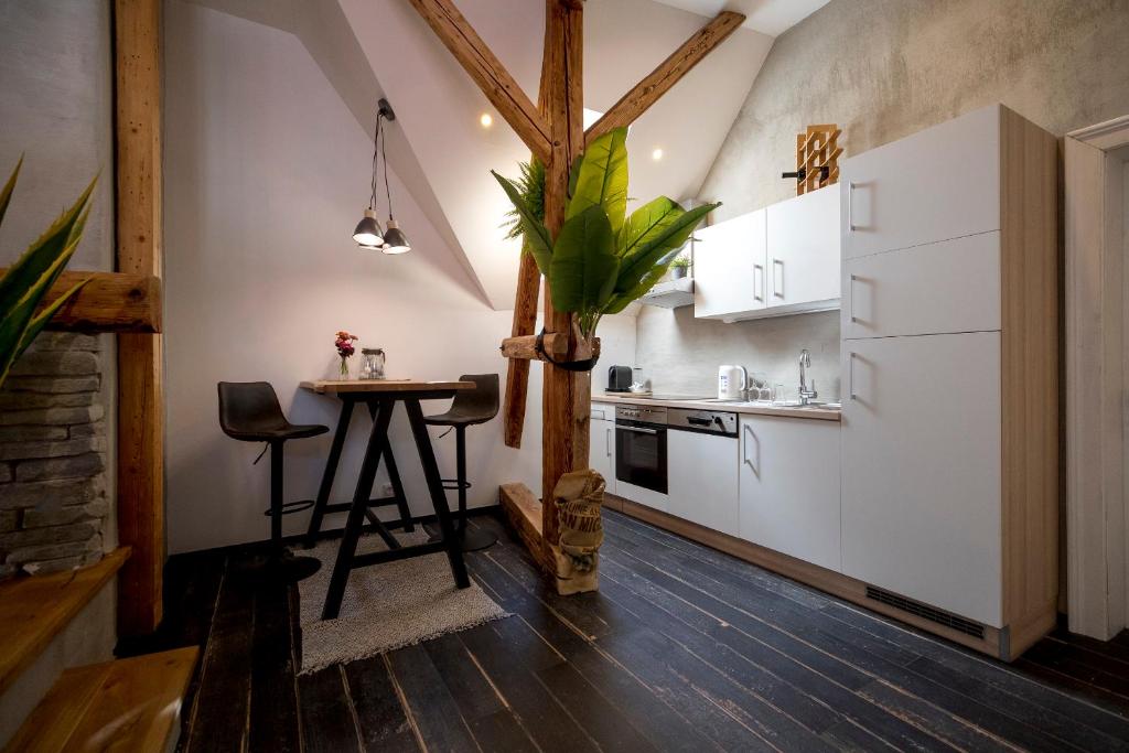 a kitchen with white cabinets and a table in a room at Studio Loft Murau - im Herzen der Altstadt in Murau