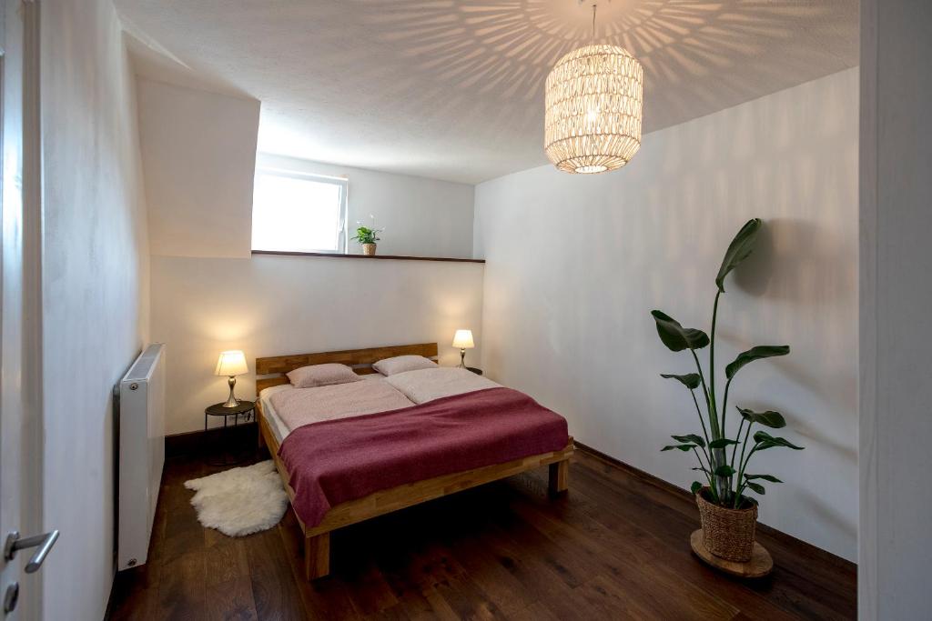a bedroom with a bed and a chandelier at Studio Loft Murau - im Herzen der Altstadt in Murau