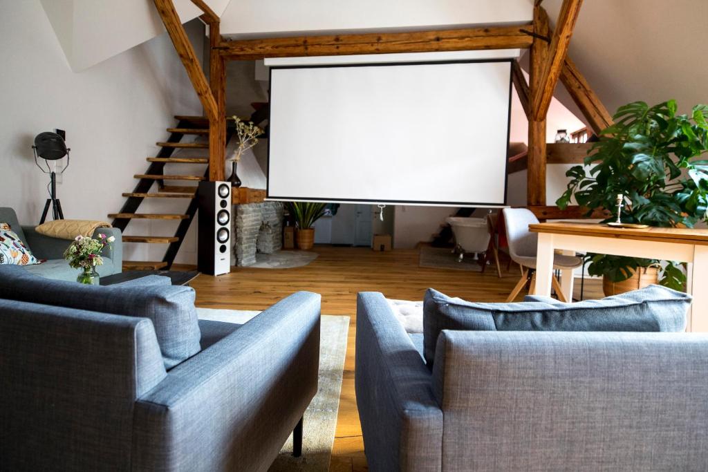 a living room with couches and a projection screen at Studio Loft Murau - im Herzen der Altstadt in Murau