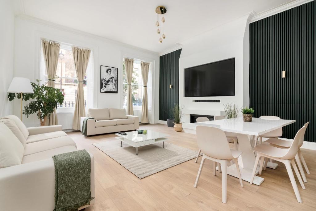 uma sala de estar com mobiliário branco e uma mesa branca em Luxury Majestic Apartment in Marylebone em Londres