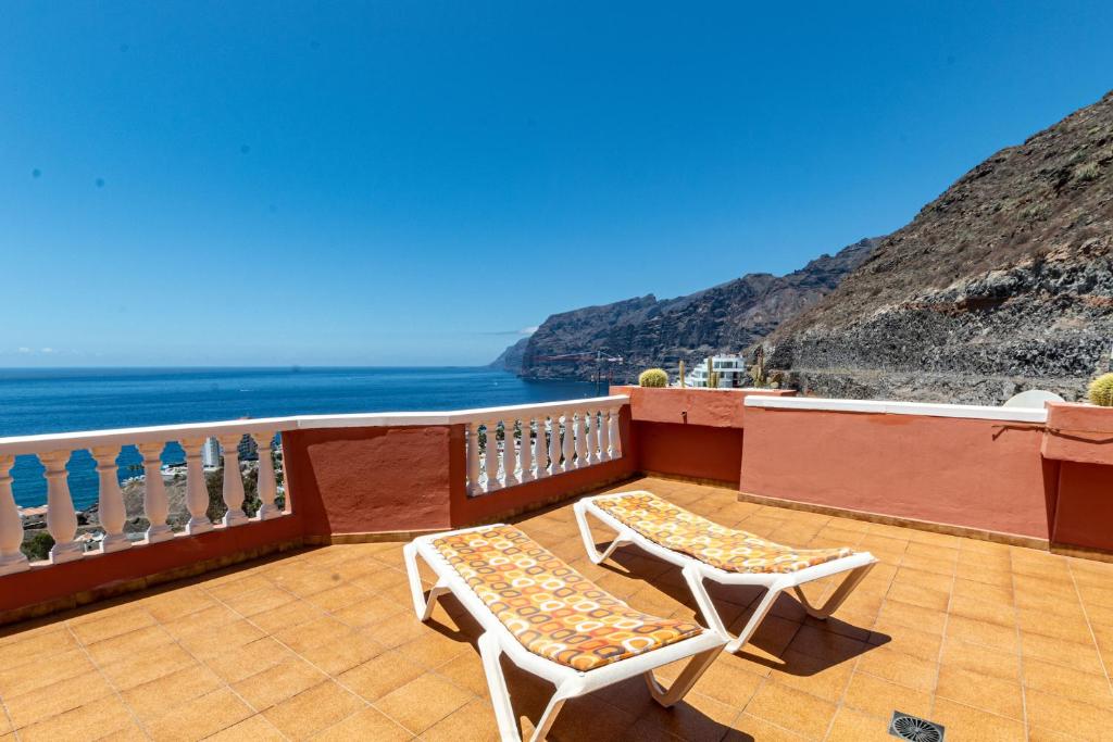 a balcony with two chairs and a view of the ocean at Fantastic View & Terrace Apt by Dream Homes Tenerife in Puerto de Santiago