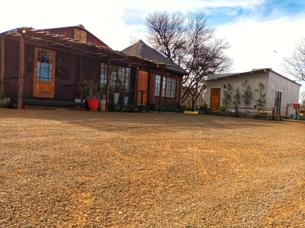 a house with a gravel driveway in front of it at Thorn Tree Bloemfontein in Bloemfontein
