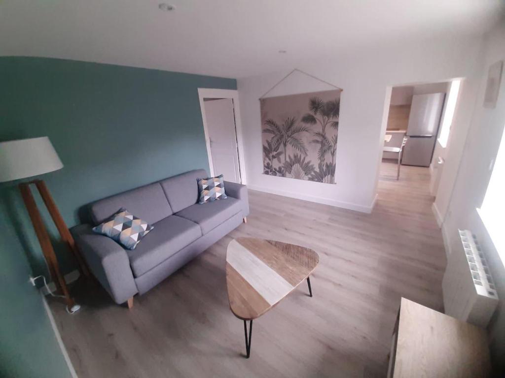 uma sala de estar com um sofá e uma mesa em Bel Appartement T2 40 M2 em Vaugneray