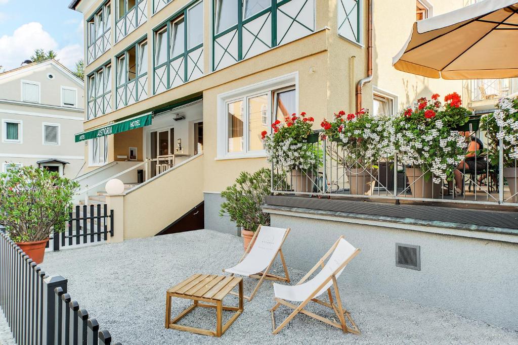 two chairs and a table in front of a building at Hotel Astoria in Salzburg