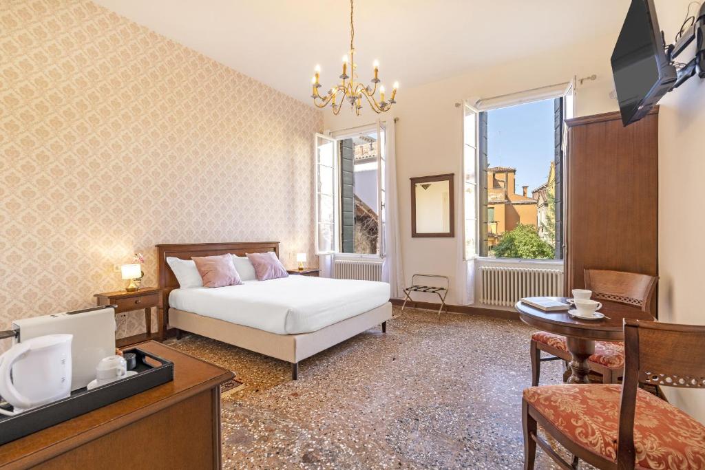 a bedroom with a bed and a tv in a room at Residenza Centopietre - Dorsoduro in Venice
