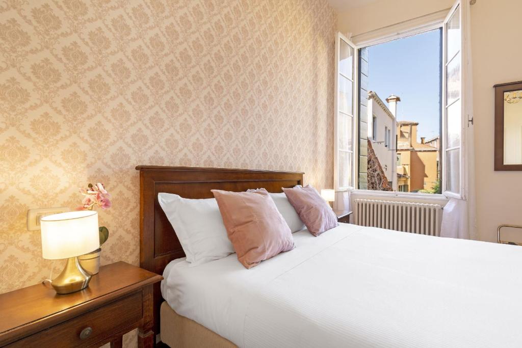 Łóżko lub łóżka w pokoju w obiekcie Residenza Centopietre - Dorsoduro by Wonderful Italy