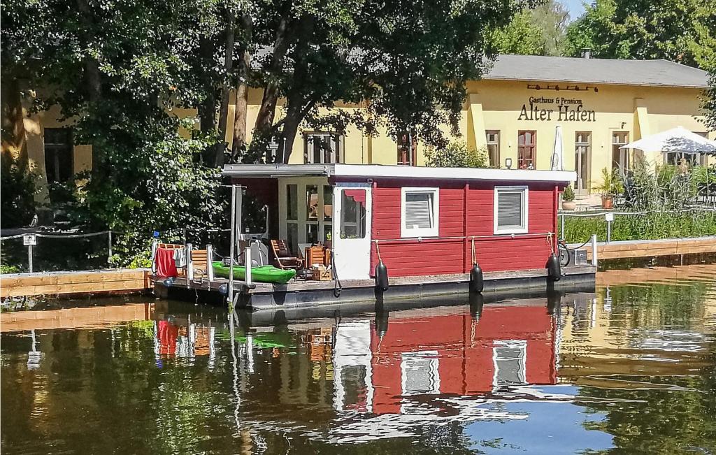 a small house on a boat on a body of water at Stunning Ship In Brandenburg With Lake View in Kützkow