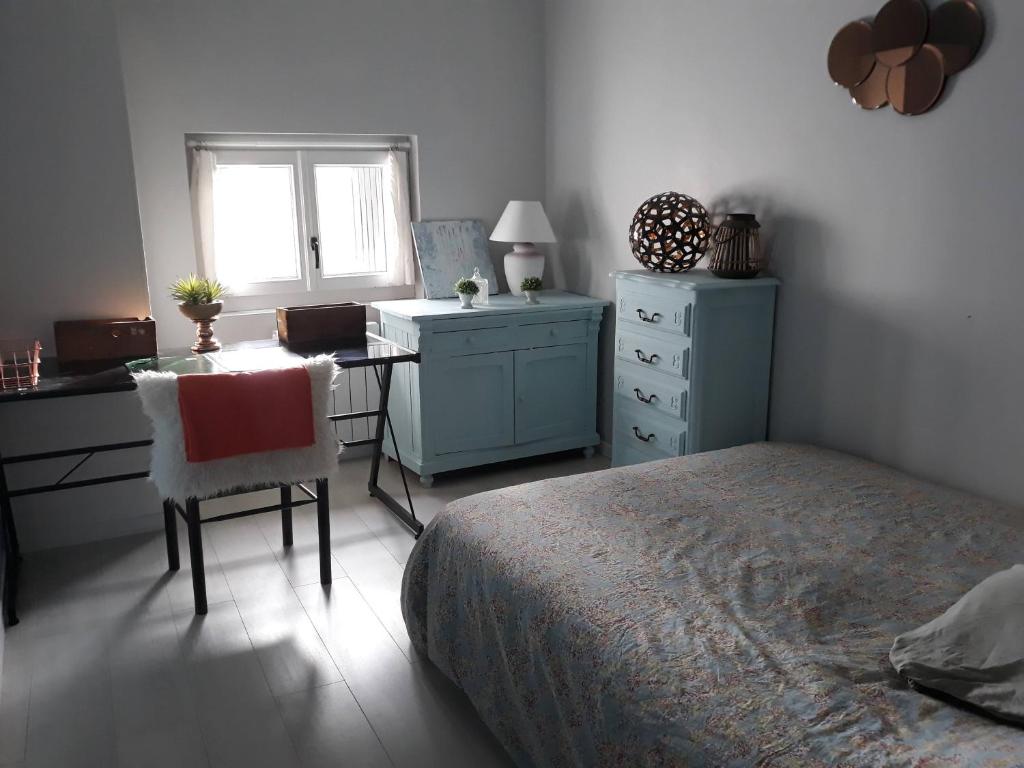 um quarto com uma cama, uma secretária e uma mesa em Maison toulousaine calme- charme-sérénité em Grenade-sur-Garonne