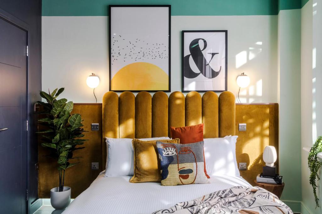 a bedroom with a bed with a wooden headboard at Your Apartment I Brixton in London