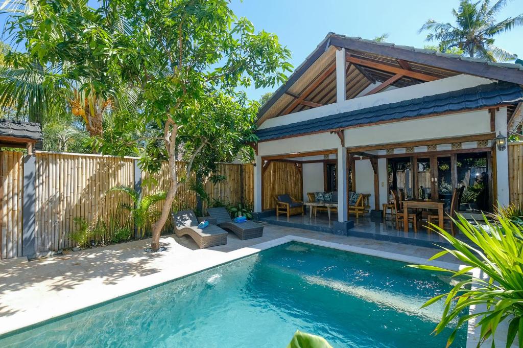 a swimming pool in front of a house at 3 Angels Villa with Private Pool in Gili Islands
