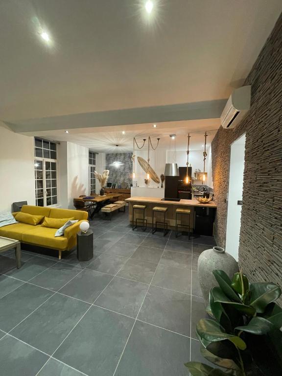 un salon avec un canapé jaune et une table dans l'établissement Appart 110m2 terrasse climatisé quartier médiéval, à Clermont-Ferrand