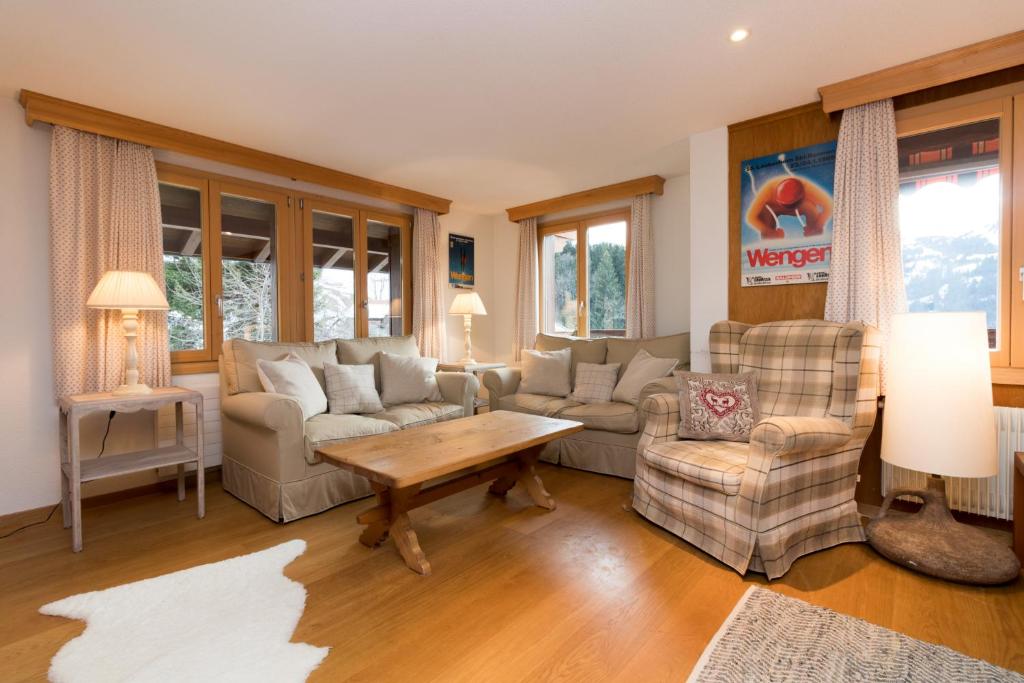 a living room with a couch and chairs and a table at Chalet Eigersunne 2 in Wengen
