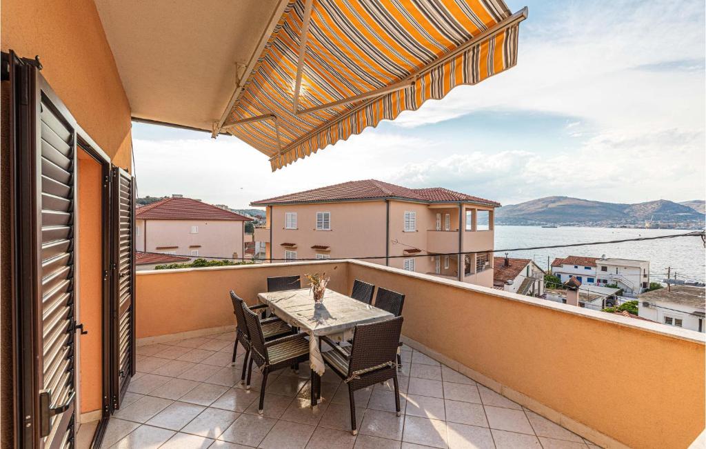 a patio with a table and chairs on a balcony at Lovely Apartment In Okrug Gornji With Wifi in Trogir
