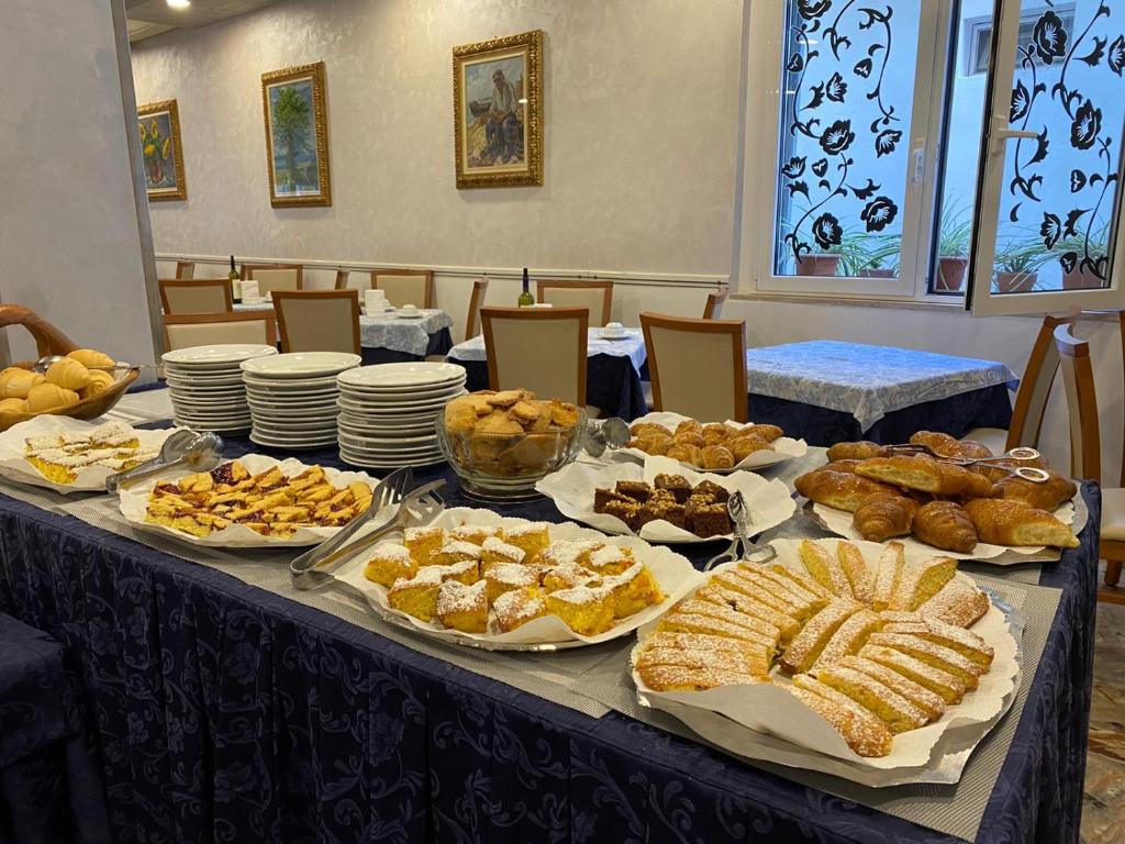 een tafel gevuld met verschillende soorten brood en gebak bij Hotel Erika in Rimini
