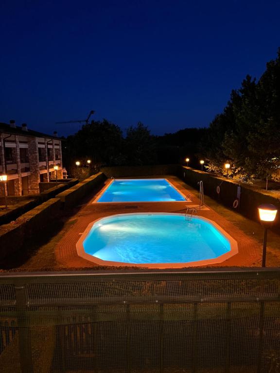 a group of three swimming pools at night at Appartamento Lago Playa in Desenzano del Garda