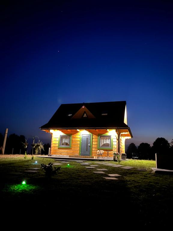 a small house with lights on it at night at Domek do wynajęcia - Siedlisko przy lesie in Rząśnik