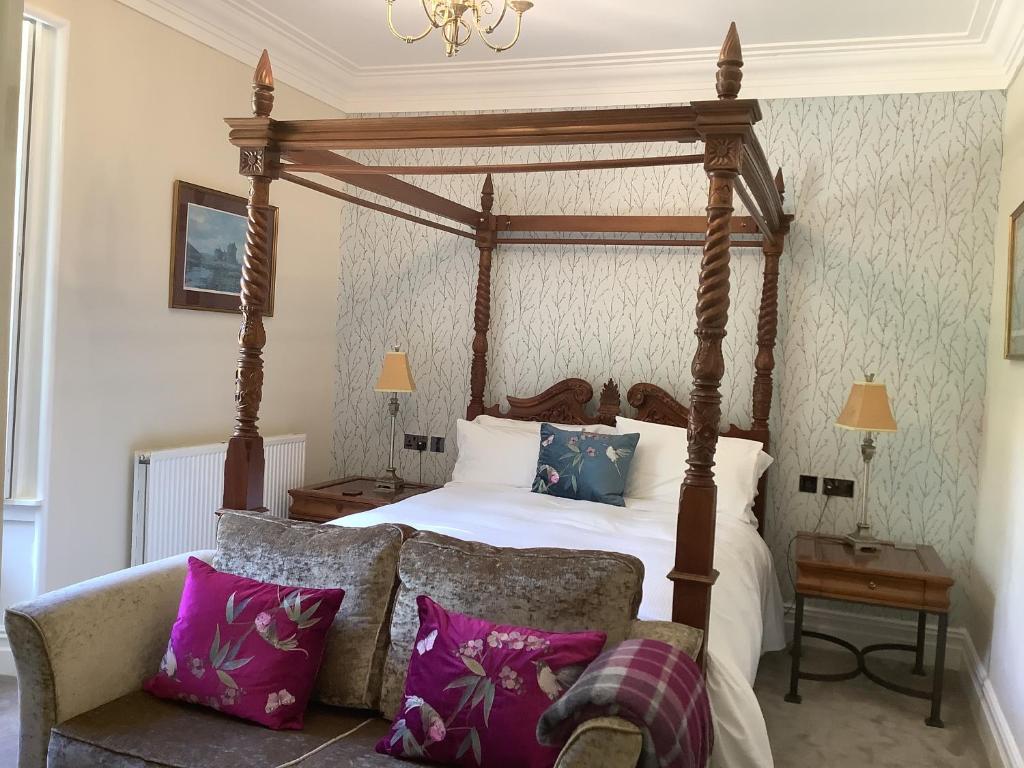 a bedroom with a four poster bed with purple pillows at Brookfield House Warcop in Warcop