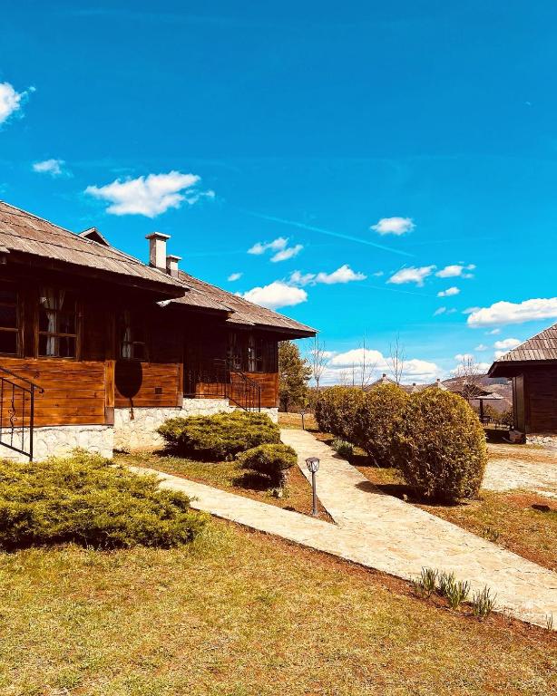 a house with a pathway next to a building at ETNO SELO VRANEŠA Zlatar in Nova Varoš
