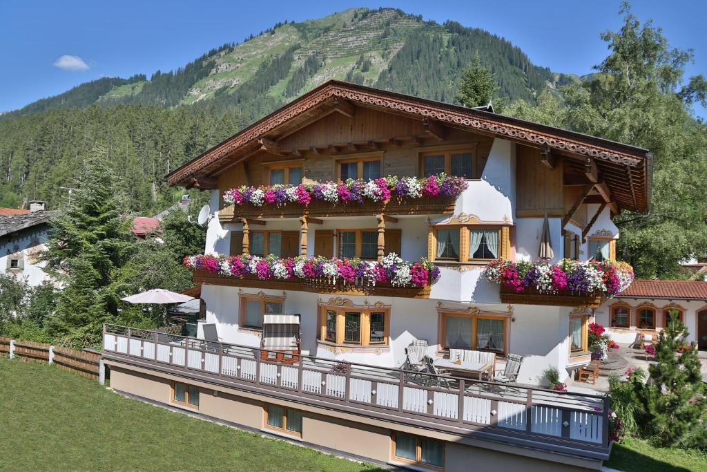 une maison avec des fleurs sur le balcon dans l'établissement Landhaus Marion, à Holzgau