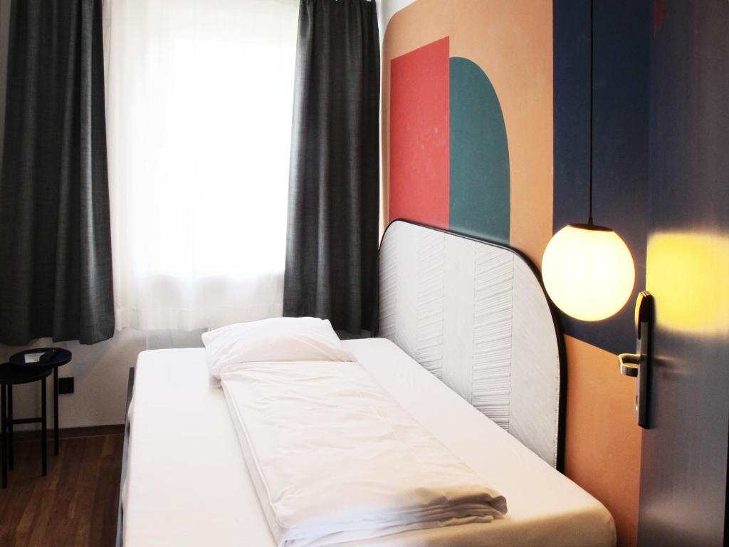 um quarto com duas camas e uma janela em The Dot | 24/7 Checkin em Munique