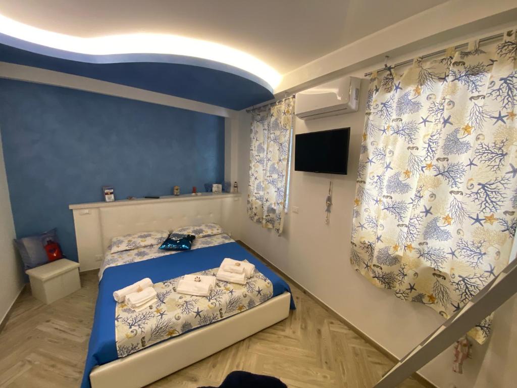 Schlafzimmer mit einem Bett mit blauen Wänden und Vorhängen in der Unterkunft MarEtna in Giardini-Naxos