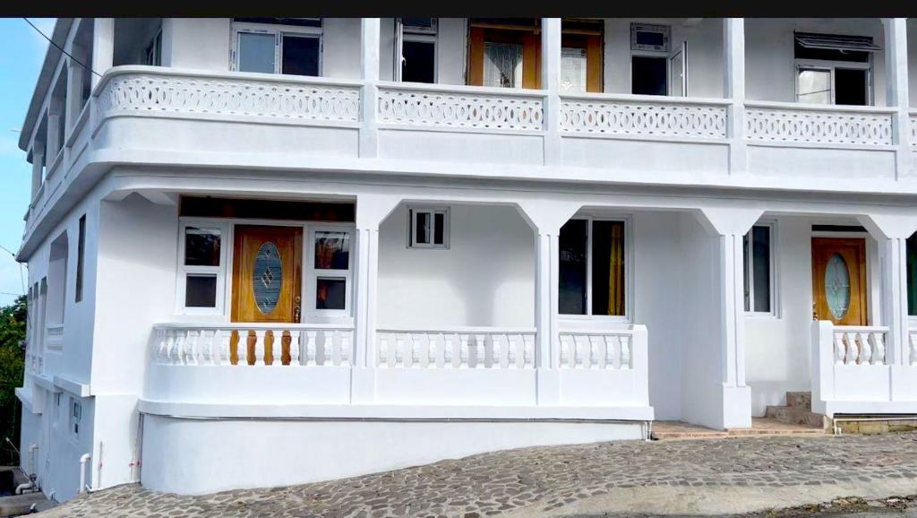 The Golden Inn في Marigot: مبنى أبيض مع شرفة على جانبه