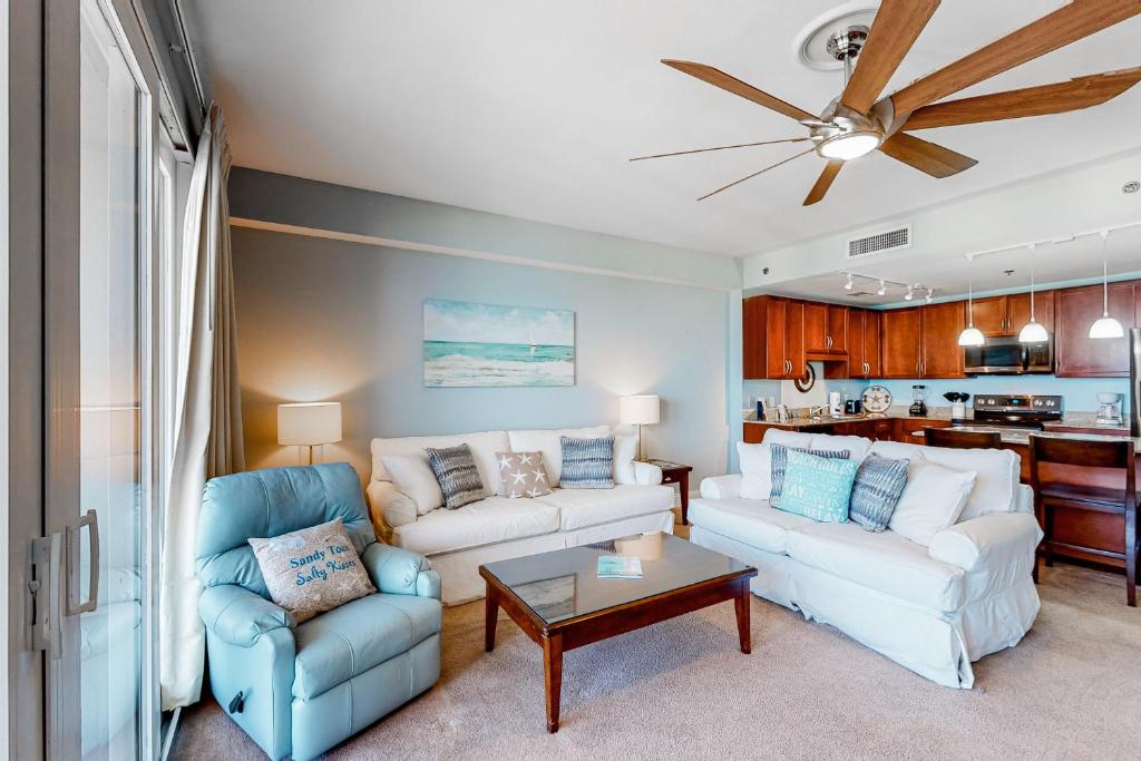 a living room with two couches and a ceiling fan at Laketown Wharf 1815 in Panama City Beach