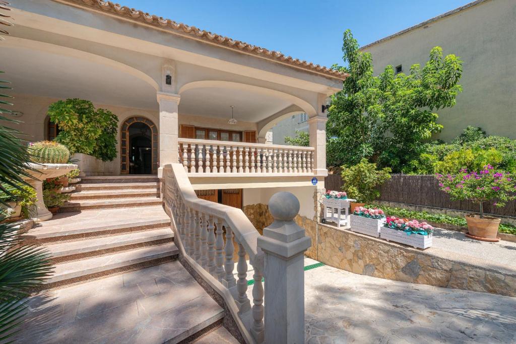 ein Haus mit einer Treppe, die zu einer Veranda führt in der Unterkunft Villa Roses - Alcúdia in Alcúdia