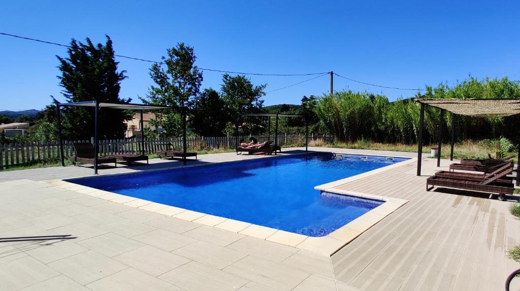 - une piscine avec 2 chaises et un kiosque dans l'établissement Superbe chambre avec terrasse, parking privé, jardin, calme, climatisation, 10 mn pont du Gard #7, à Rochefort-du-Gard