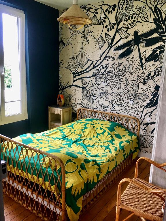 1 dormitorio con 1 cama y papel pintado con motivos florales en Chambre privée les Clottins dans maison en Baillet-en-France