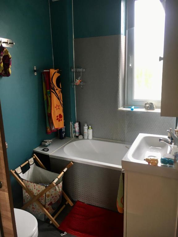 y baño con bañera y lavamanos. en Chambre privée les Clottins dans maison en Baillet-en-France