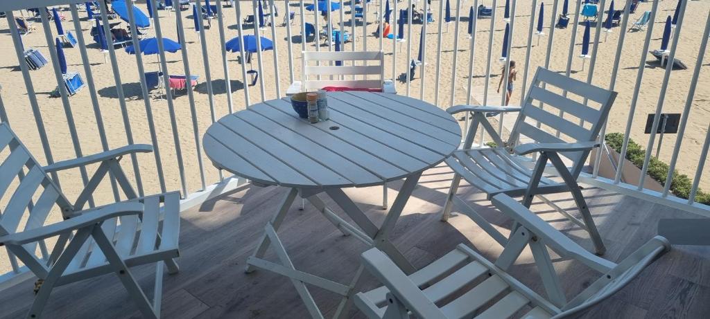 uma mesa e duas cadeiras e uma praia em Condomino Giuditta em Porto Santa Margherita di Caorle