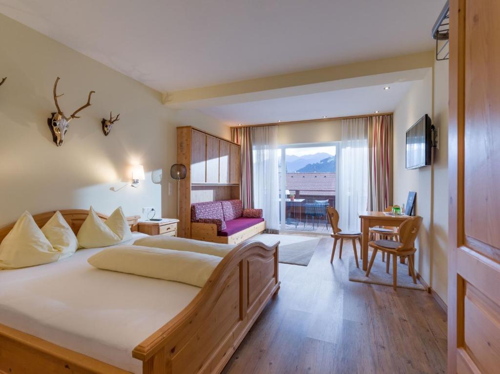 Postel nebo postele na pokoji v ubytování Das Sonnleiten Ski- und Motorradhotel Bruck im Zillertal