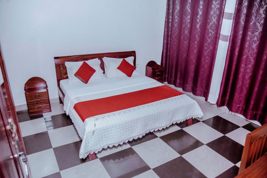 a bedroom with a bed and a checkered floor at Martin Aviator Hotel in Kigali