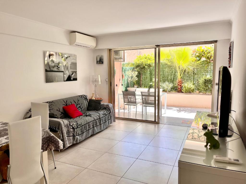 sala de estar con sofá y puerta corredera de cristal en Apartment Cannes Rico Beach en Cannes