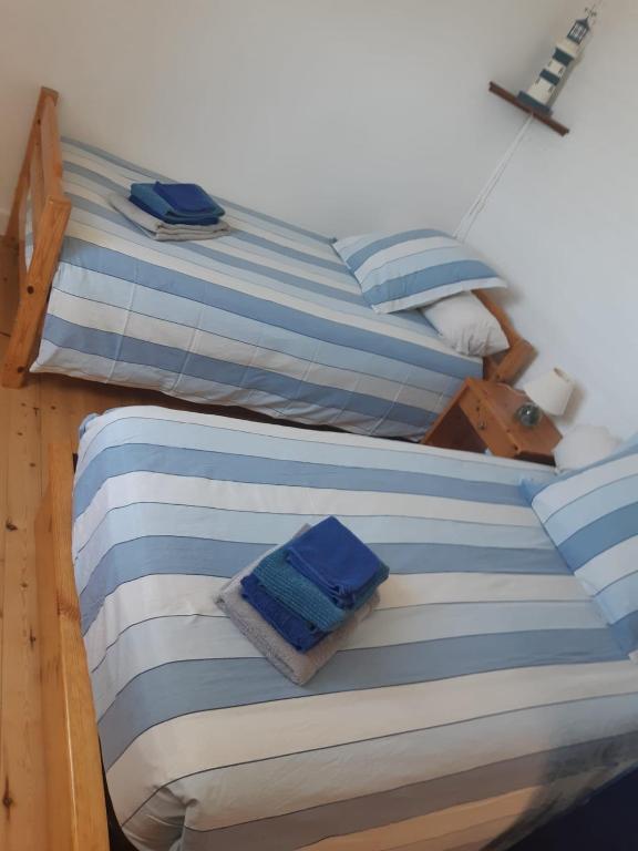 two twin beds with blue and white striped sheets at Maison typique bretonne a 5 min de la plage a pied in Crozon