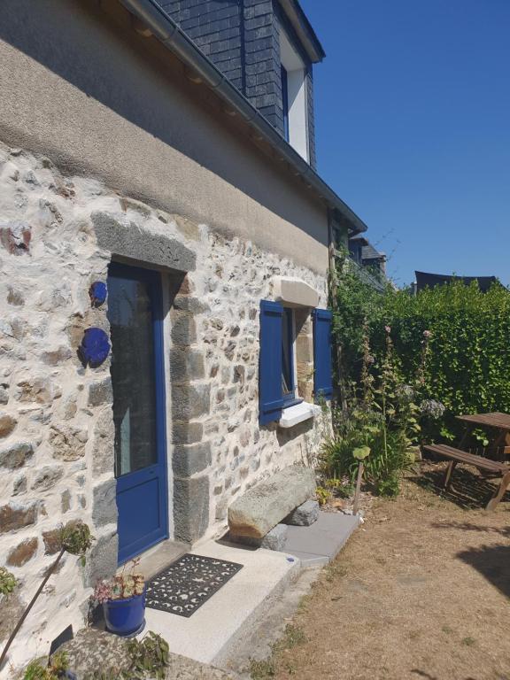 a stone house with blue doors and a bench at Maison typique bretonne a 5 min de la plage a pied in Crozon