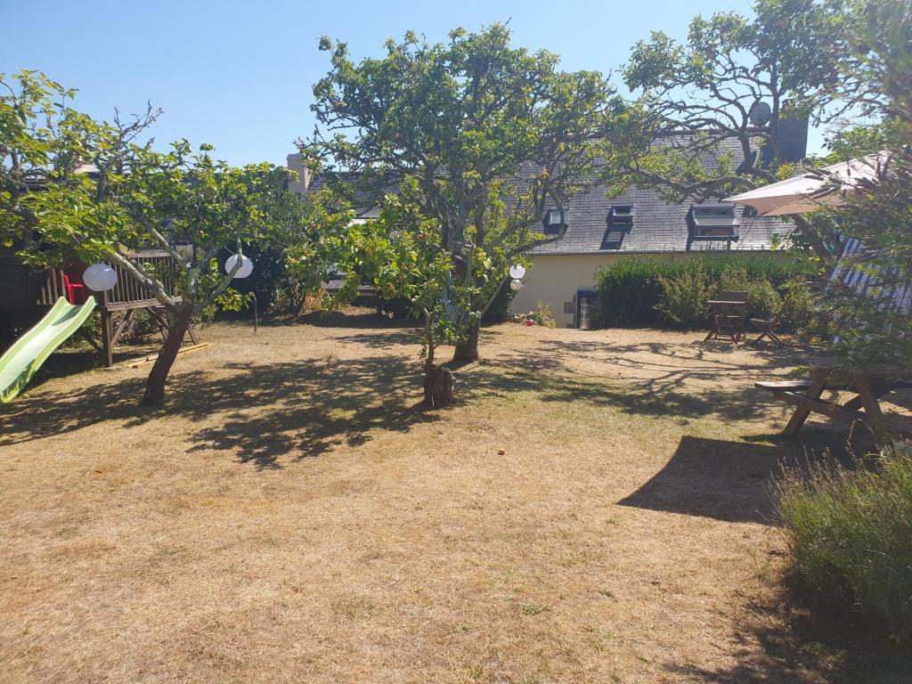 a yard with a slide and trees and a house at Maison typique bretonne a 5 min de la plage a pied in Crozon