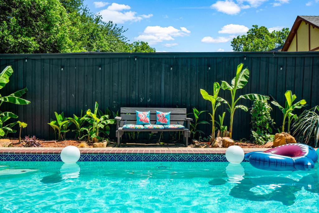 una piscina con un banco junto a una valla en Dallas Oak Lawn Oasis w/ Private Pool, Hot Tub, en Dallas