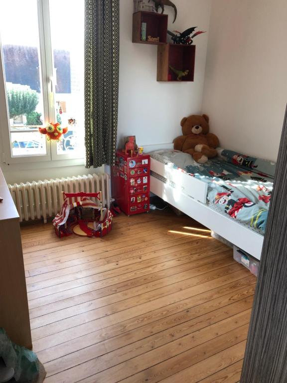 ein Schlafzimmer mit einem Bett mit einem Teddybär drauf in der Unterkunft Home Sweet Home in Baillet-en-France