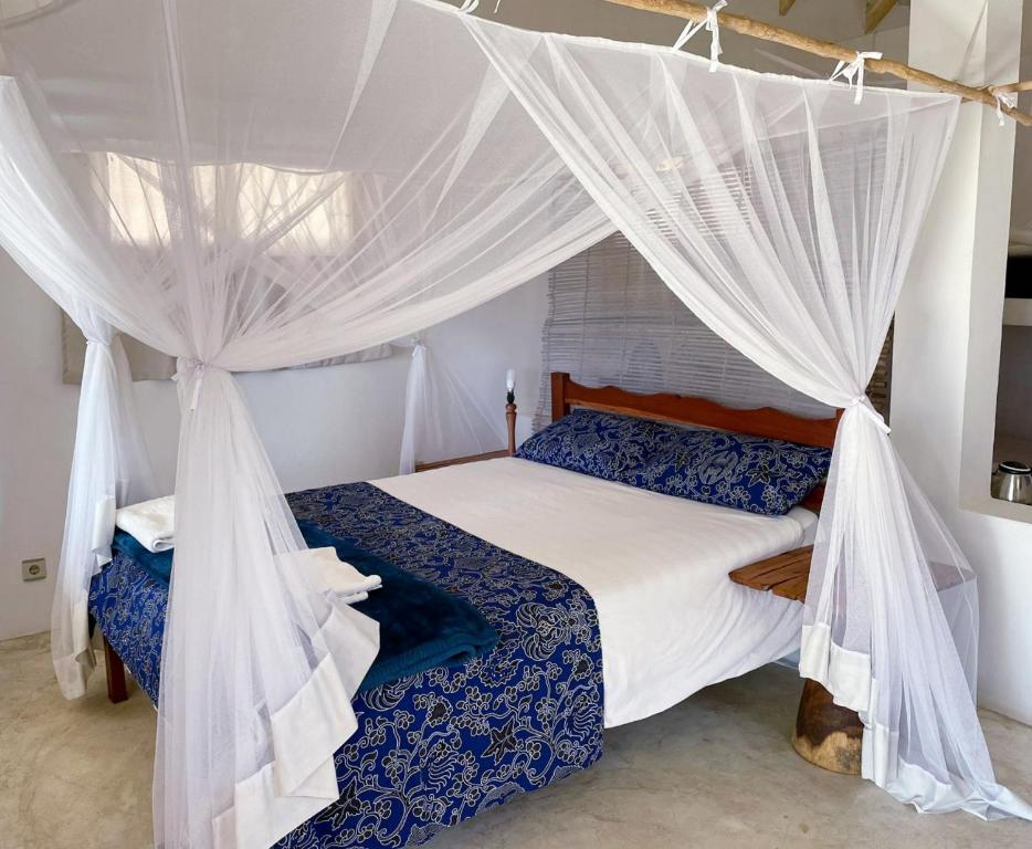 1 dormitorio con 1 cama con mosquiteras en Baobab Beach Vilanculos, en Vilanculos