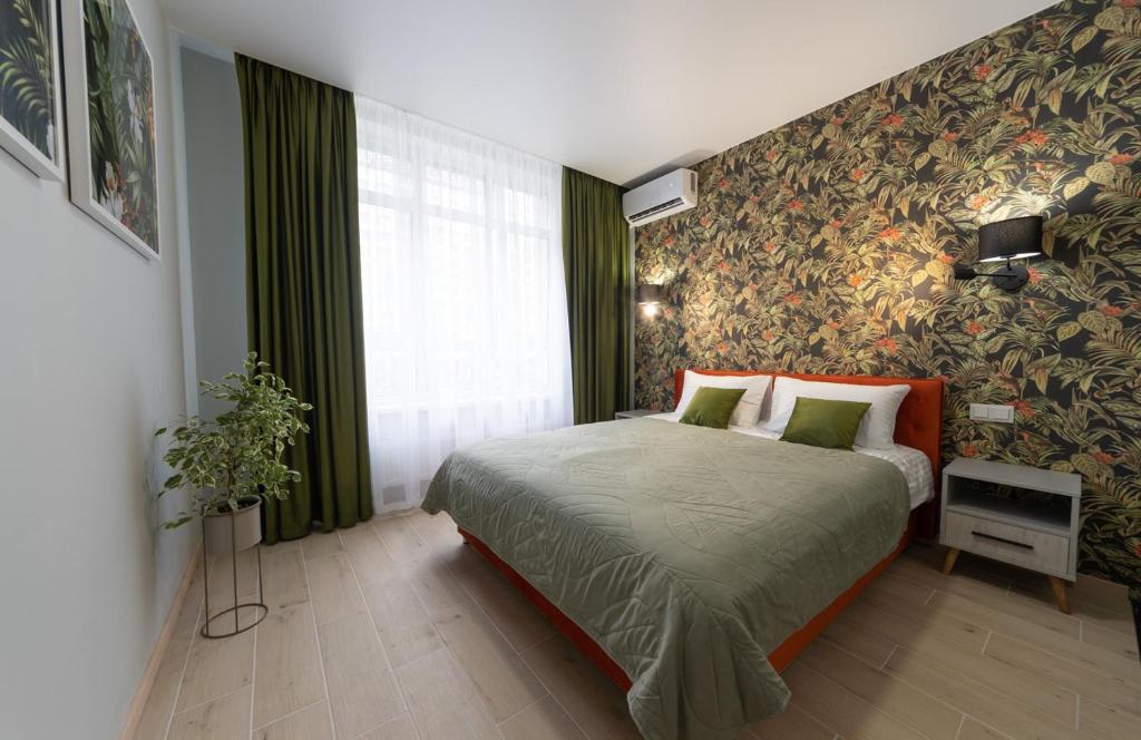a bedroom with a bed and a wall covered in flowers at Апартаменти MYFREEDOM поруч із метро Сирець in Kyiv