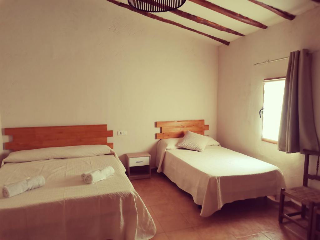 1 dormitorio con 2 camas y ventana en CASA MOYA-LA ENCARNACIÓN, en Caravaca de la Cruz