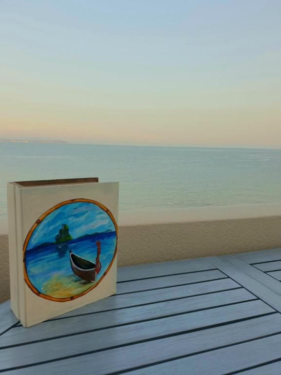 a book with a painting of a boat on the beach at Platsa Studios in Megás Limniónas