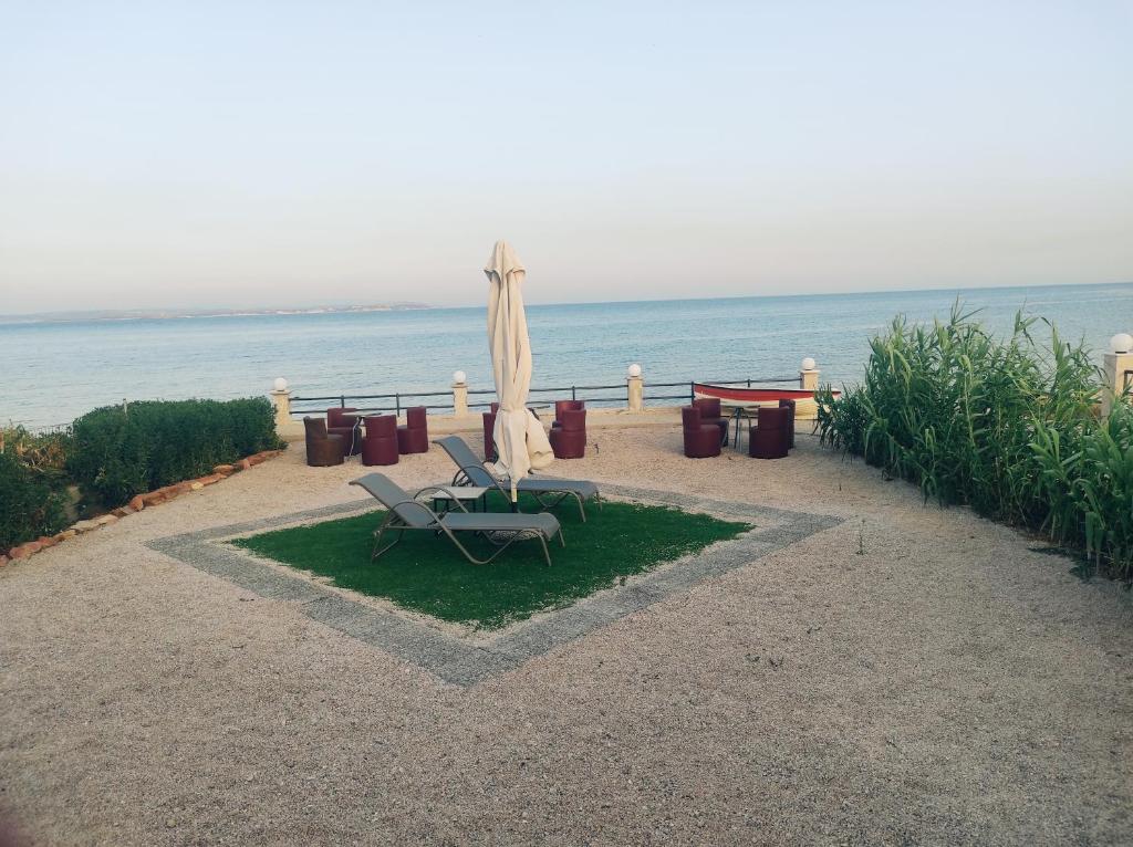 a patio with two chairs and an umbrella and the ocean at Platsa Studios in Megás Limniónas