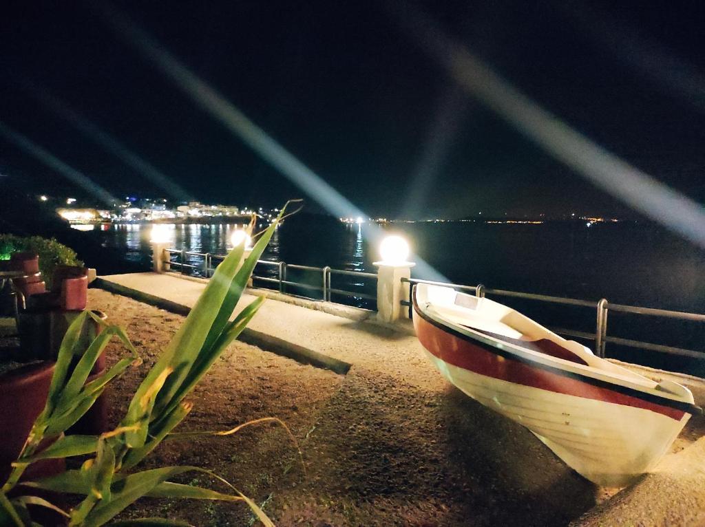 a boat sitting on the side of the water at night at Platsa Studios in Megás Limniónas