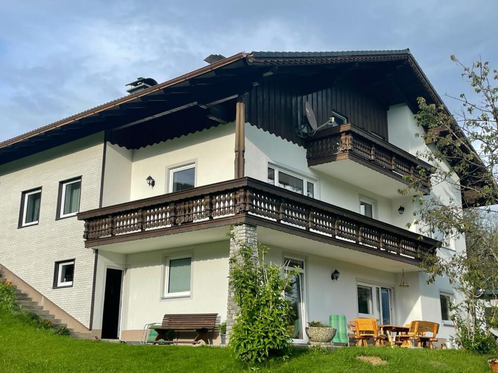 a large white house with a balcony at Ferienwohnung ,Hoizmann` in Pinsdorf